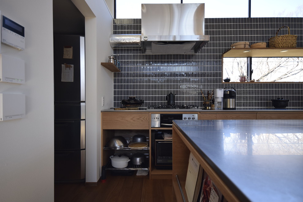 Photo of a scandinavian galley open plan kitchen in Tokyo Suburbs with an integrated sink, beige cabinets, stainless steel benchtops, beige splashback, timber splashback, stainless steel appliances, medium hardwood floors, with island and brown floor.