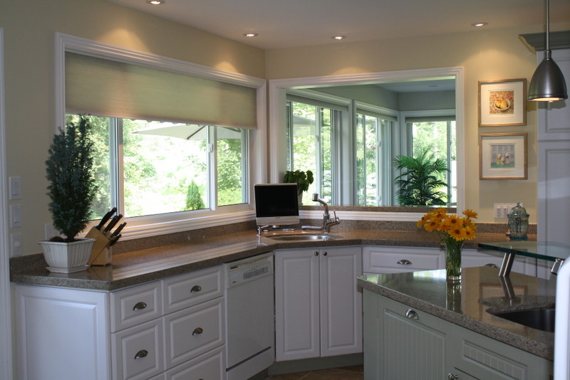 Inspiration for a transitional u-shaped travertine floor kitchen remodel in Toronto with an undermount sink, raised-panel cabinets, white cabinets, quartz countertops, stainless steel appliances and an island
