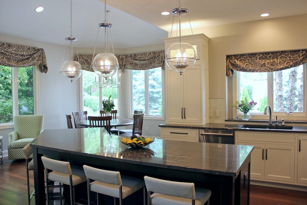 Inspiration for a mid-sized transitional l-shaped dark wood floor eat-in kitchen remodel with a double-bowl sink, shaker cabinets, white cabinets, granite countertops, white backsplash, glass tile backsplash, stainless steel appliances and an island