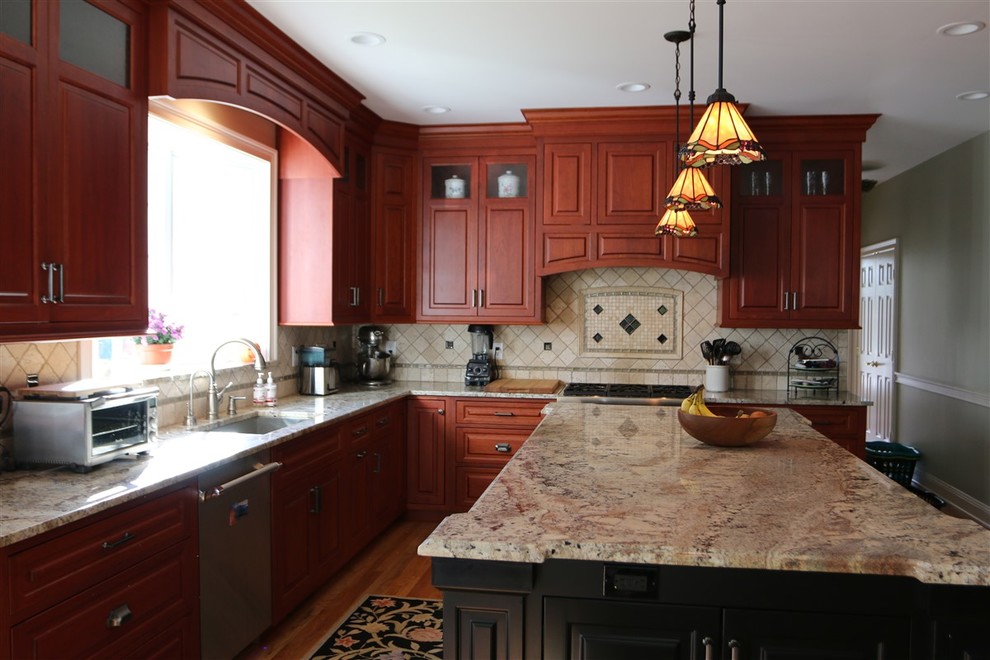 Photo of a mid-sized arts and crafts l-shaped eat-in kitchen in New York with raised-panel cabinets, medium wood cabinets, granite benchtops, with island, an undermount sink, beige splashback, ceramic splashback, stainless steel appliances and medium hardwood floors.