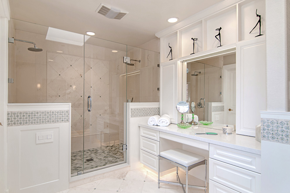 This is an example of a large transitional master bathroom in San Diego with raised-panel cabinets, white cabinets, a freestanding tub, a double shower, white tile, white walls, limestone floors, an undermount sink, engineered quartz benchtops, a one-piece toilet, stone tile and white floor.
