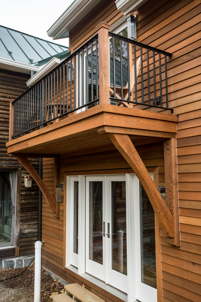 Aménagement d'une façade de maison marron campagne en bois et bardage à clin de taille moyenne et à un étage avec un toit à deux pans et un toit végétal.