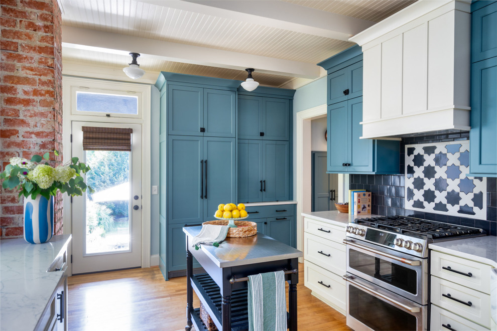 Klassisk inredning av ett litet vit vitt kök, med gröna skåp, bänkskiva i kvarts, blått stänkskydd, stänkskydd i keramik, rostfria vitvaror, marmorgolv, en köksö och vitt golv