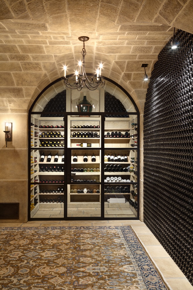 This is an example of a mediterranean wine cellar in Other with display racks and beige floor.
