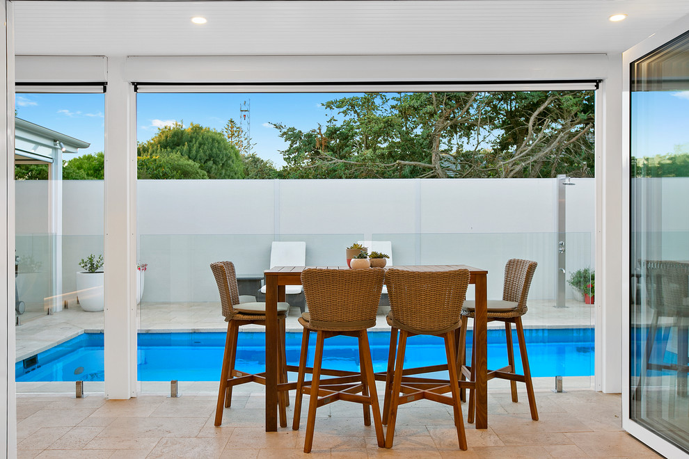 This is an example of a beach style backyard patio in Melbourne with a roof extension.