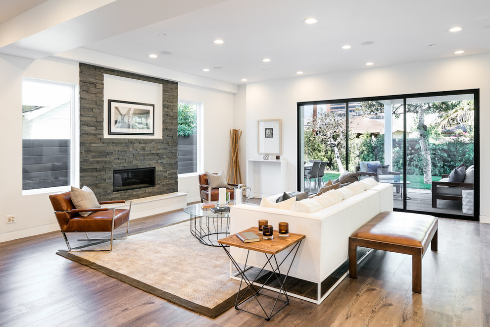 Photo of a contemporary open concept living room in Los Angeles with white walls, light hardwood floors, a ribbon fireplace and a stone fireplace surround.