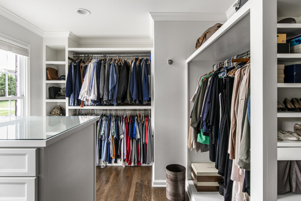 Photo of a large transitional gender-neutral walk-in wardrobe in Nashville with shaker cabinets, white cabinets and medium hardwood floors.