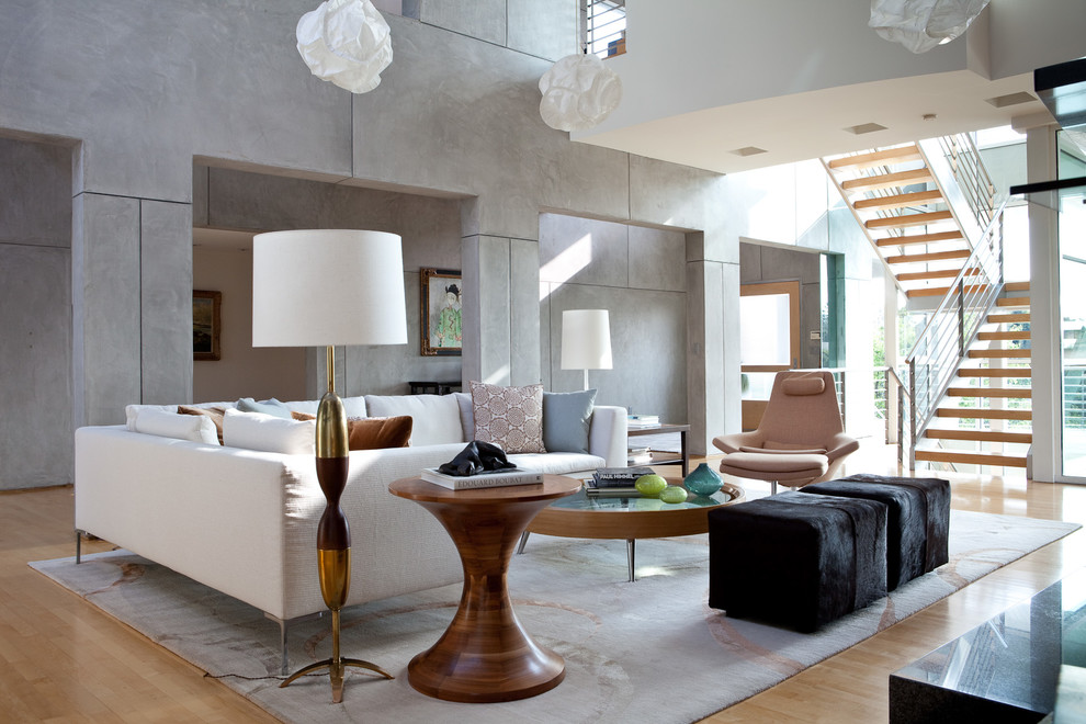 Contemporary open concept living room in Los Angeles with grey walls and light hardwood floors.