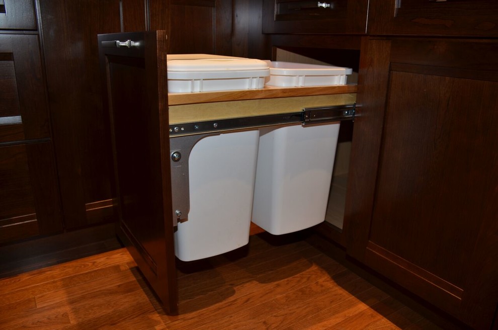 Inspiration for a large transitional l-shaped medium tone wood floor open concept kitchen remodel in Toronto with an undermount sink, recessed-panel cabinets, dark wood cabinets, quartzite countertops, gray backsplash, glass tile backsplash, stainless steel appliances and an island