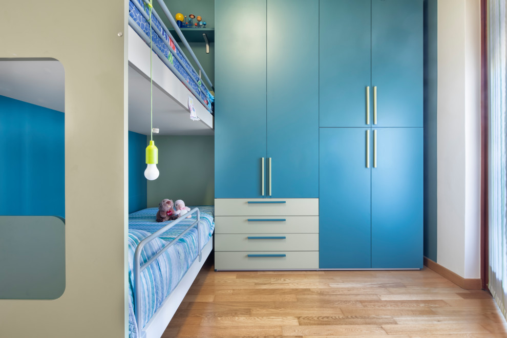 На фото: маленькая нейтральная детская в стиле модернизм с синими стенами, деревянным полом и спальным местом для на участке и в саду, ребенка от 4 до 10 лет с