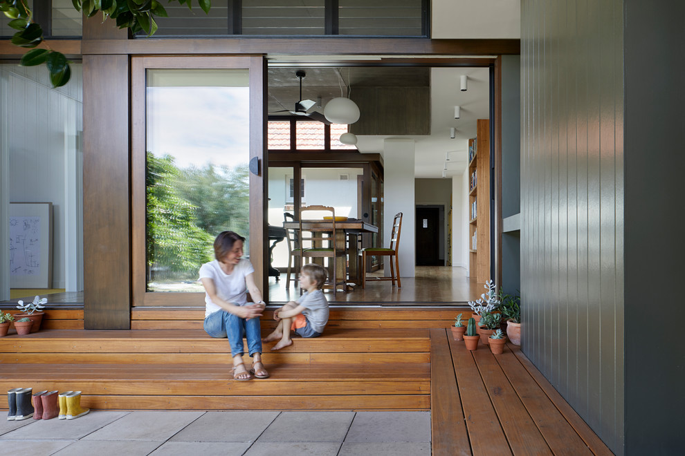 Photo of a mid-sized contemporary backyard verandah in Melbourne with concrete pavers and a roof extension.