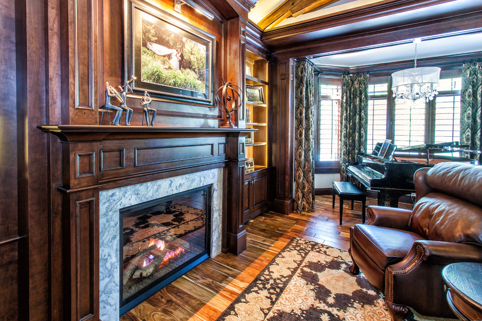 Photo of a traditional study room in Detroit with dark hardwood floors, a standard fireplace, a stone fireplace surround and a built-in desk.