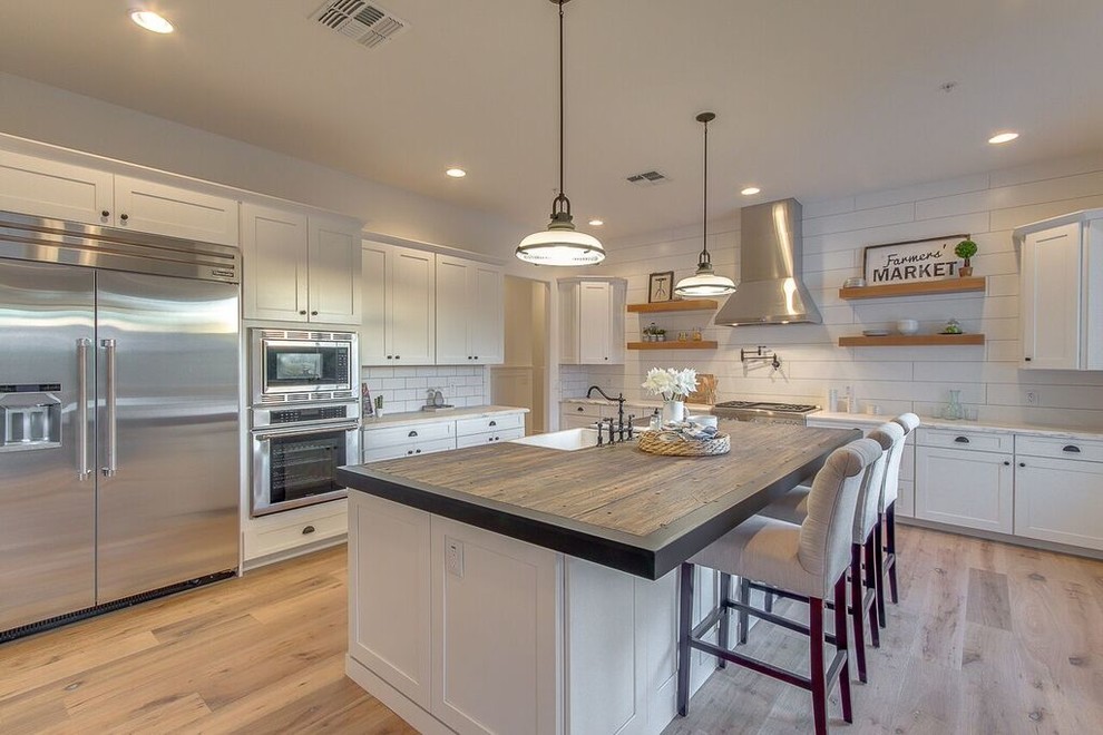 Large contemporary l-shaped eat-in kitchen in Phoenix with a farmhouse sink, white cabinets, stainless steel appliances and with island.