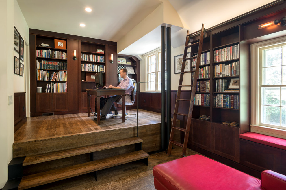 Design ideas for an industrial home office in DC Metro with a freestanding desk and a library.