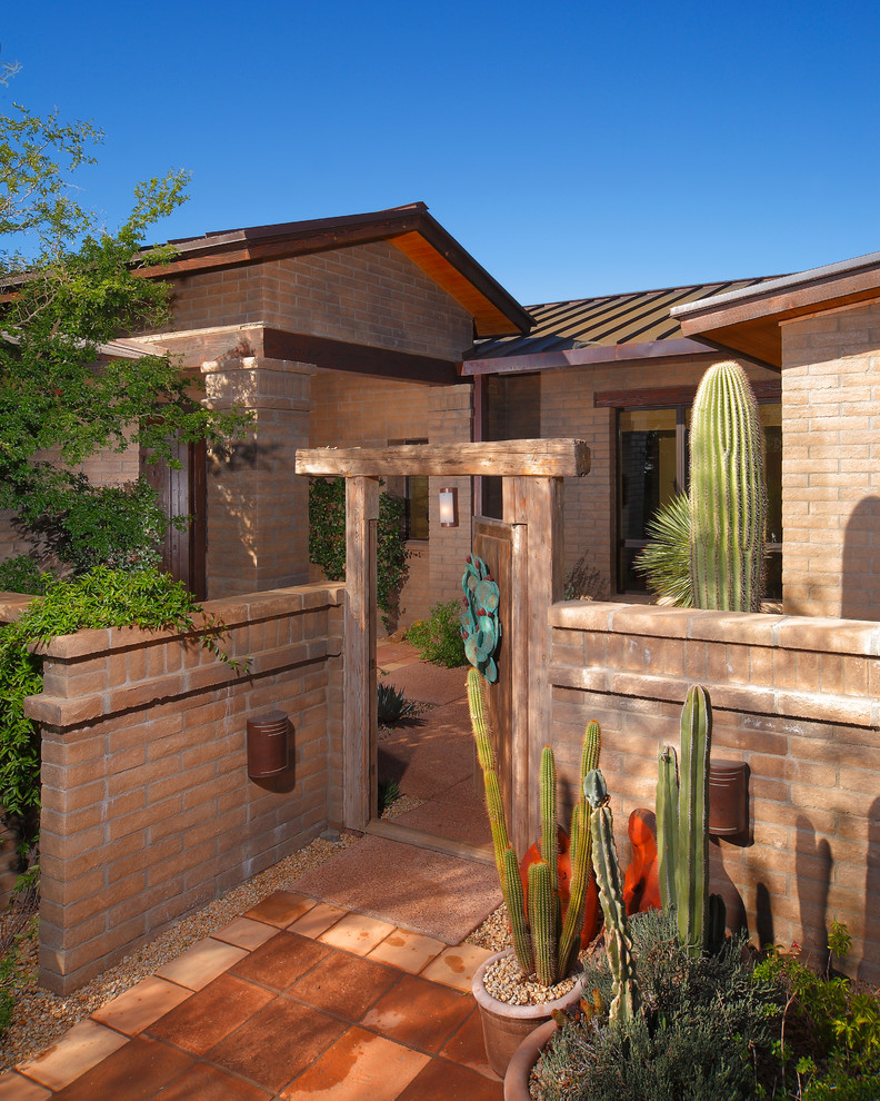 Front door - large rustic terra-cotta tile front door idea in Phoenix with beige walls and a medium wood front door