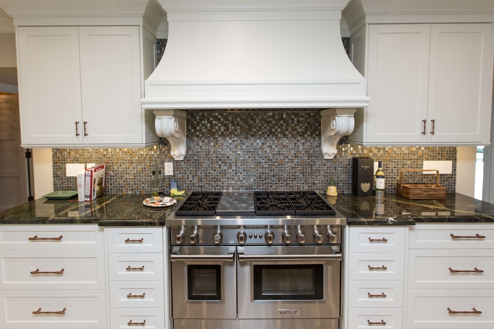 Example of a large transitional u-shaped light wood floor open concept kitchen design in Miami with a farmhouse sink, shaker cabinets, stainless steel appliances, an island, white cabinets, granite countertops, metallic backsplash and mosaic tile backsplash