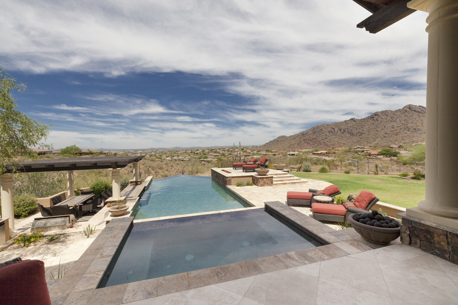 This is an example of a large contemporary backyard rectangular lap pool in Phoenix with natural stone pavers.