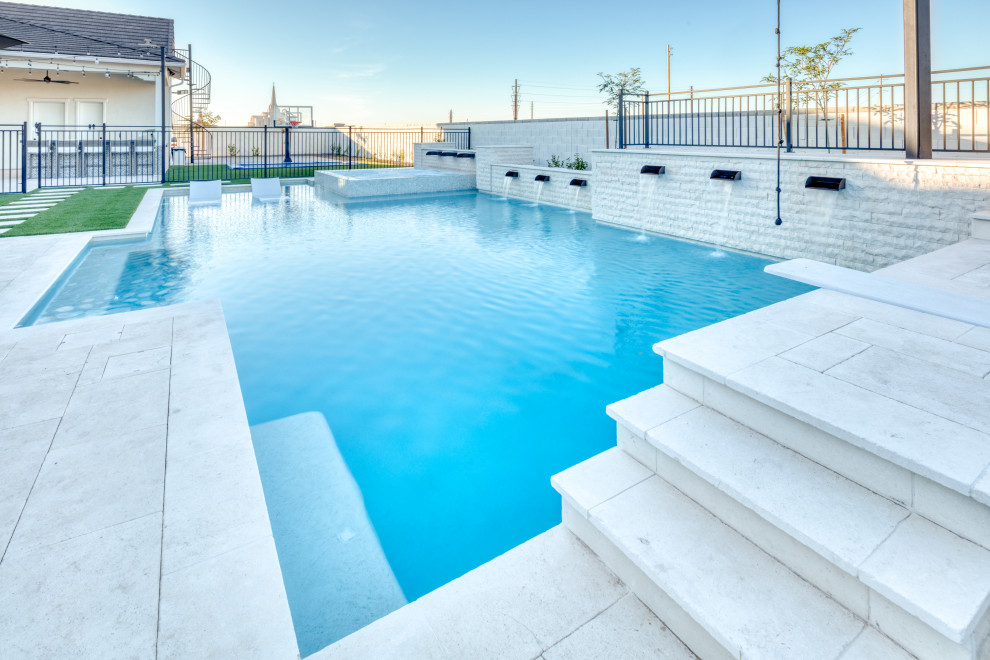 Imagen de piscina natural actual grande a medida en patio trasero con paisajismo de piscina y adoquines de piedra natural
