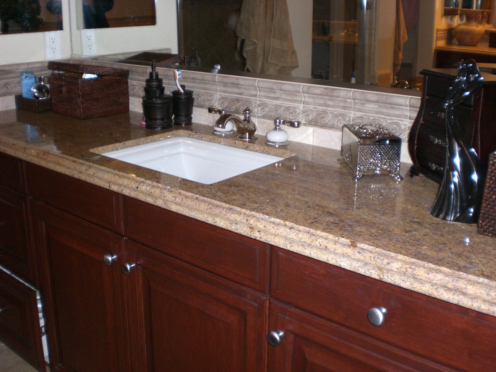 This is an example of a small traditional 3/4 bathroom in Orange County with raised-panel cabinets, medium wood cabinets, beige walls, porcelain floors, an undermount sink, granite benchtops and beige floor.