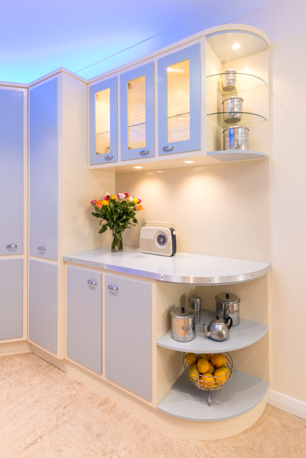 This is an example of a large eclectic u-shaped separate kitchen in Adelaide with a double-bowl sink, raised-panel cabinets, blue cabinets, laminate benchtops, white splashback, glass sheet splashback, black appliances, white walls, linoleum floors and with island.