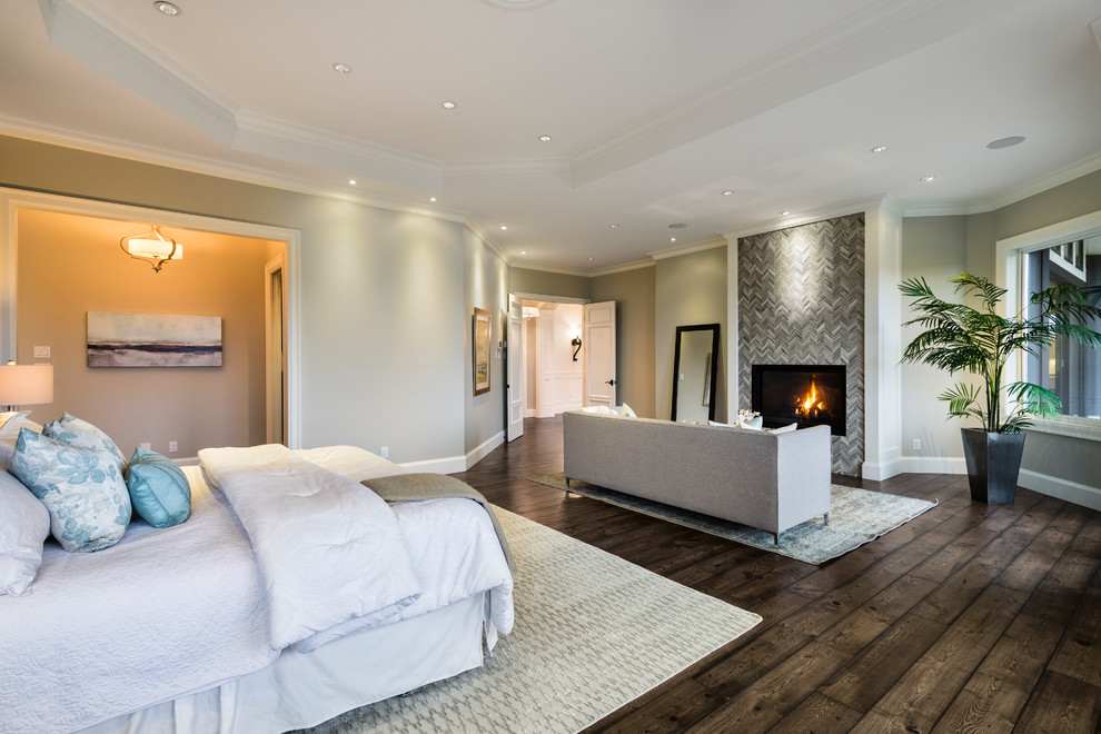 Design ideas for an expansive transitional master bedroom in Vancouver with multi-coloured walls, medium hardwood floors, a standard fireplace, a tile fireplace surround and brown floor.