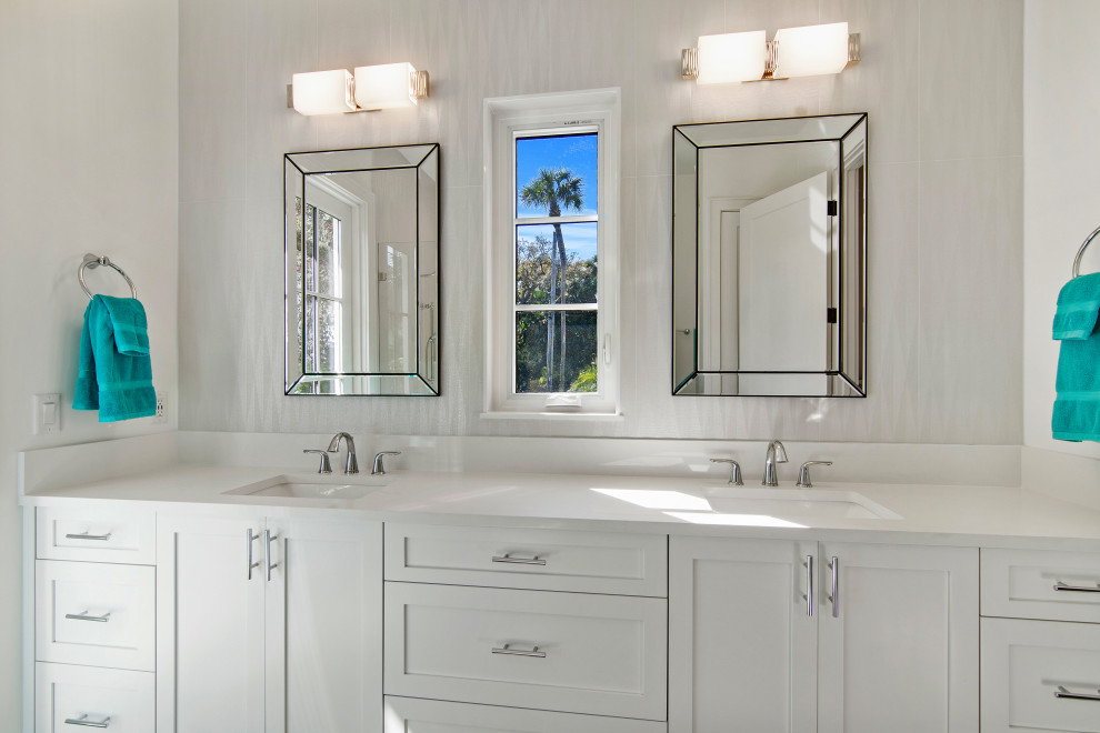 This is an example of a contemporary master bathroom in Other with shaker cabinets, white cabinets, a corner shower, white tile, porcelain tile, an undermount sink, engineered quartz benchtops, white benchtops, a double vanity and a built-in vanity.