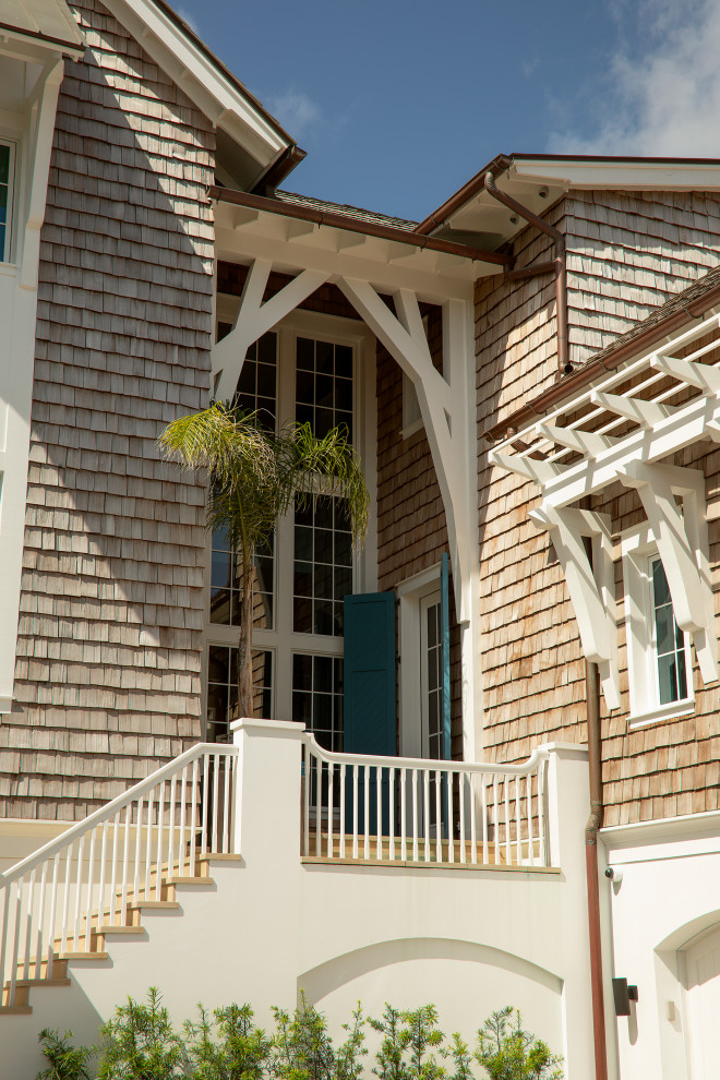Imagen de fachada de casa marrón y marrón marinera grande de tres plantas con revestimiento de madera, tejado a dos aguas, tejado de teja de madera y teja