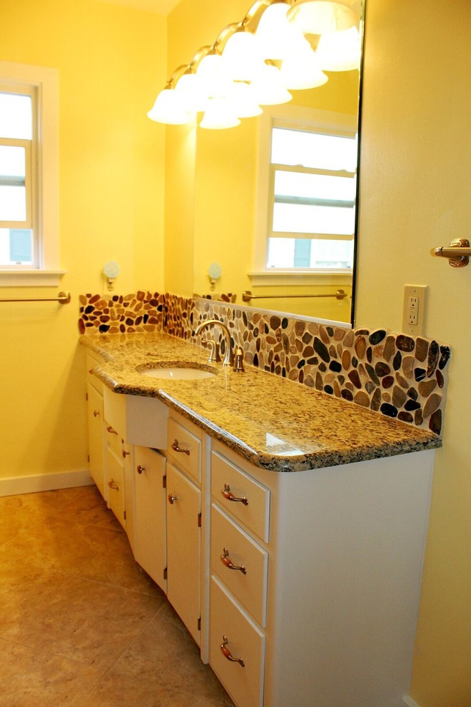 Design ideas for a mid-sized transitional bathroom in Seattle with flat-panel cabinets, white cabinets, black tile, brown tile, pebble tile, yellow walls, ceramic floors, an undermount sink and granite benchtops.