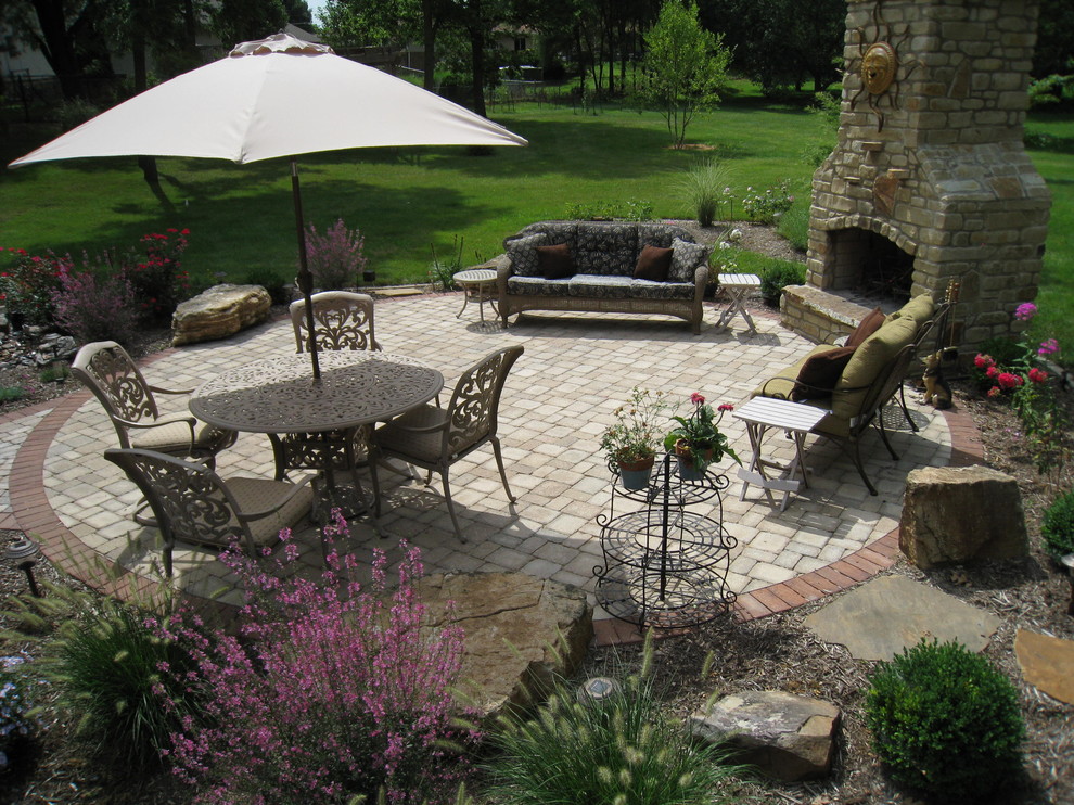 Inspiration for a mid-sized traditional backyard patio in Chicago with a fire feature, concrete pavers and no cover.