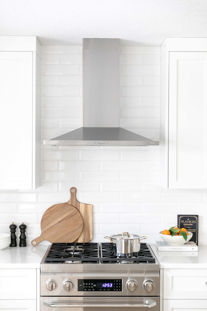Inspiration for a large transitional u-shaped medium tone wood floor and brown floor eat-in kitchen remodel in Calgary with an undermount sink, shaker cabinets, white cabinets, quartzite countertops, white backsplash, subway tile backsplash, stainless steel appliances, an island and white countertops
