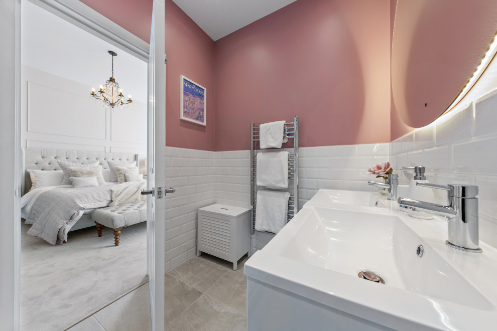 Design ideas for a medium sized contemporary grey and pink ensuite bathroom in London with flat-panel cabinets, white cabinets, a corner shower, a wall mounted toilet, white tiles, metro tiles, pink walls, ceramic flooring, grey floors, a hinged door, white worktops, feature lighting, double sinks and a floating vanity unit.