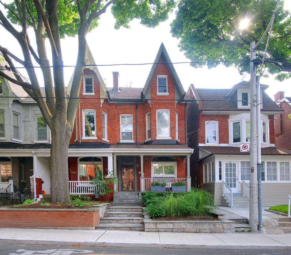 Photo of a mid-sized traditional three-storey brick red exterior in Toronto.