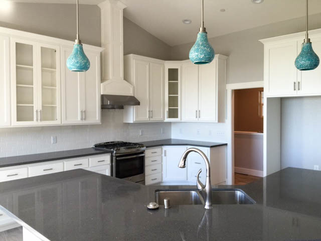 Open concept kitchen - mid-sized transitional l-shaped medium tone wood floor and gray floor open concept kitchen idea with a double-bowl sink, shaker cabinets, white cabinets, quartzite countertops, white backsplash, subway tile backsplash, stainless steel appliances and an island