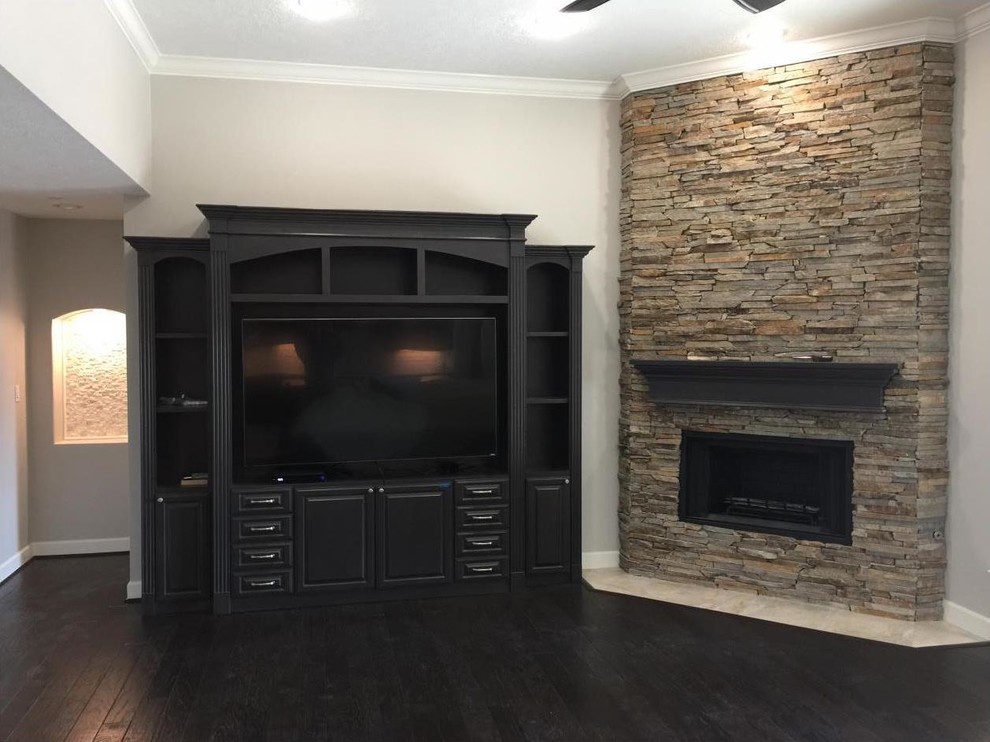 Design ideas for a large transitional open concept family room in Houston with grey walls, dark hardwood floors, a standard fireplace, a stone fireplace surround, a built-in media wall and brown floor.