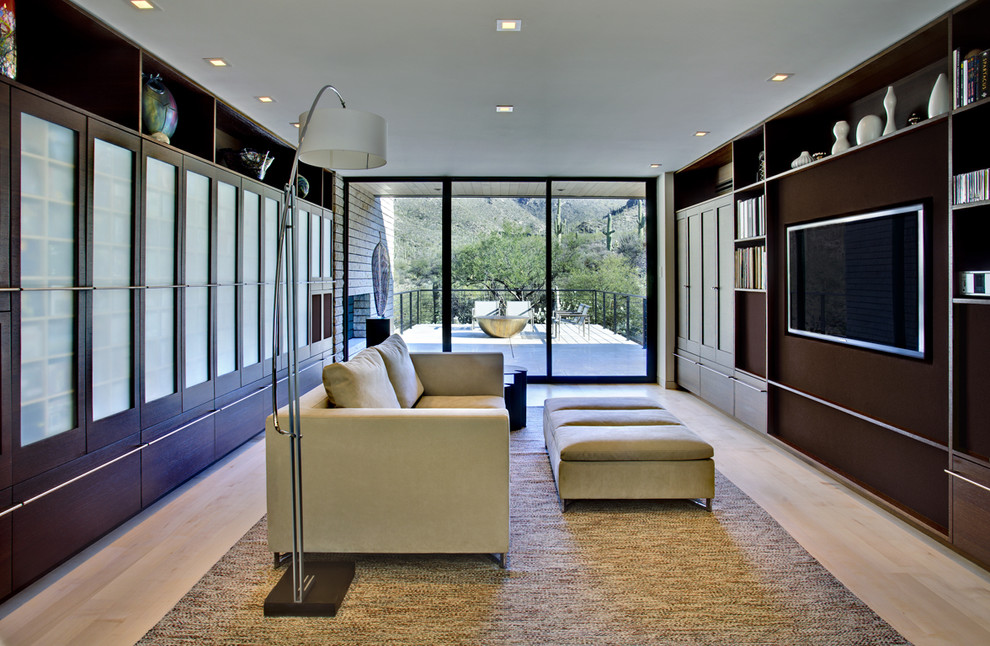 Design ideas for a contemporary family room in Phoenix with light hardwood floors and a built-in media wall.