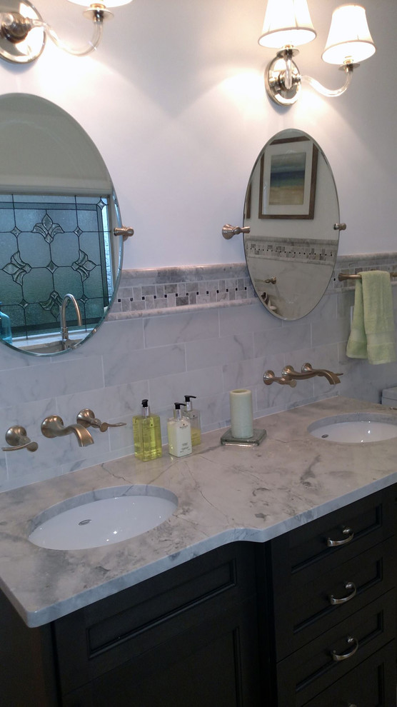 Freestanding bathtub - mid-sized transitional master black and white tile and porcelain tile porcelain tile freestanding bathtub idea with white walls, an undermount sink, granite countertops, gray cabinets and a two-piece toilet