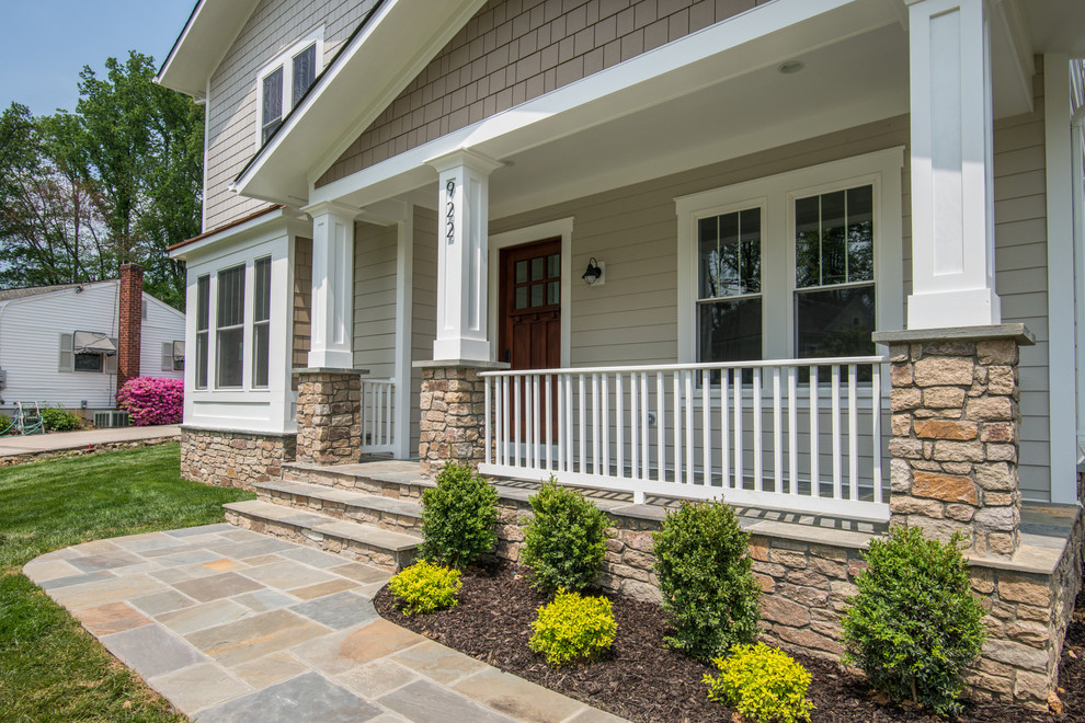 Photo of a large arts and crafts front yard patio in DC Metro with natural stone pavers and a roof extension.