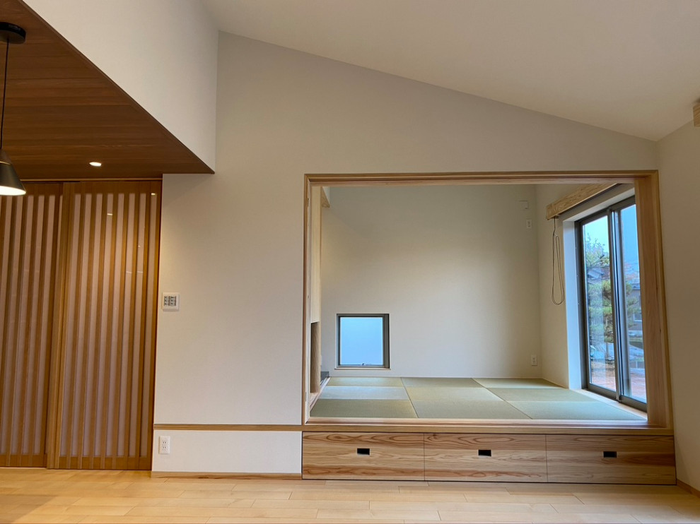 Пример оригинального дизайна: маленькая изолированная гостиная комната в стиле модернизм с белыми стенами, татами, зеленым полом, потолком с обоями и обоями на стенах без телевизора для на участке и в саду