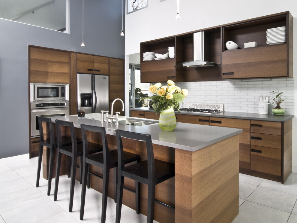 Inspiration for a contemporary kitchen in Atlanta with stainless steel appliances, a double-bowl sink, flat-panel cabinets, medium wood cabinets, quartz benchtops, white splashback and subway tile splashback.