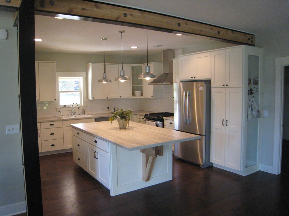 This is an example of a small farmhouse l-shaped open plan kitchen in Grand Rapids with a double-bowl sink, shaker cabinets, yellow cabinets, laminate countertops, yellow splashback, ceramic splashback, stainless steel appliances and multiple islands.