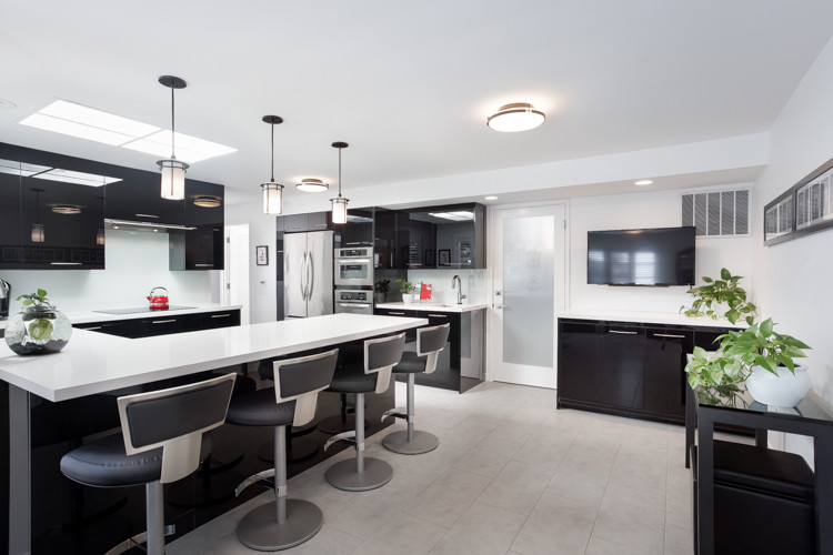 This is an example of a contemporary u-shaped kitchen in San Francisco with an undermount sink, flat-panel cabinets, black cabinets, white splashback, glass sheet splashback, stainless steel appliances and a peninsula.