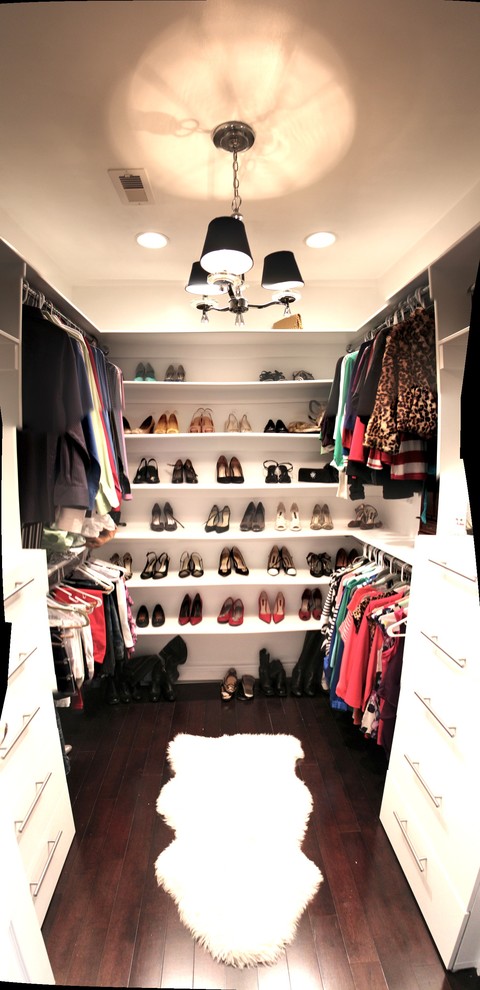 This is an example of a small gender-neutral walk-in wardrobe in Miami with open cabinets, white cabinets and dark hardwood floors.