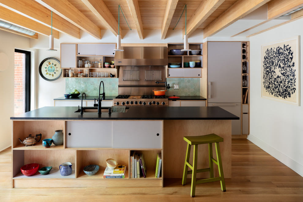 Exempel på ett klassiskt svart linjärt svart kök och matrum, med en undermonterad diskho, släta luckor, grå skåp, bänkskiva i kvarts, stänkskydd i keramik, integrerade vitvaror, mellanmörkt trägolv, en köksö, brunt golv och grönt stänkskydd