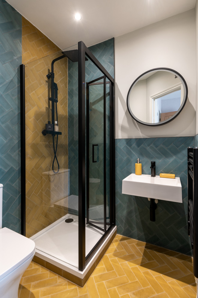 Idéer för ett litet modernt en-suite badrum, med en toalettstol med separat cisternkåpa, flerfärgad kakel, cementkakel, flerfärgade väggar, cementgolv, ett väggmonterat handfat, gult golv och dusch med gångjärnsdörr