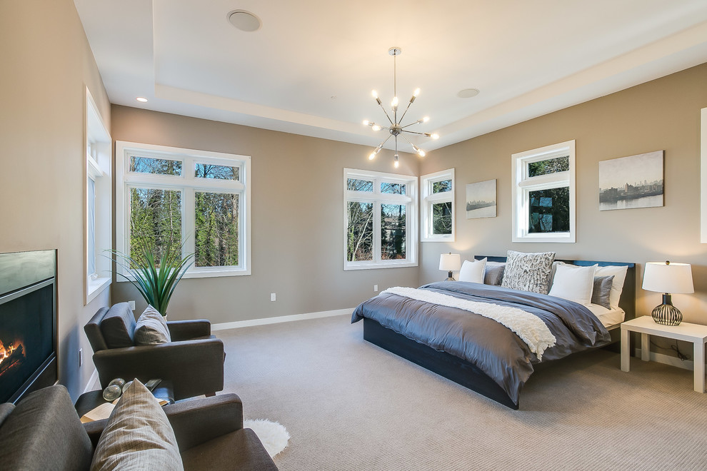 Design ideas for a mid-sized contemporary master bedroom in Seattle with beige walls, carpet, a two-sided fireplace, a plaster fireplace surround and beige floor.