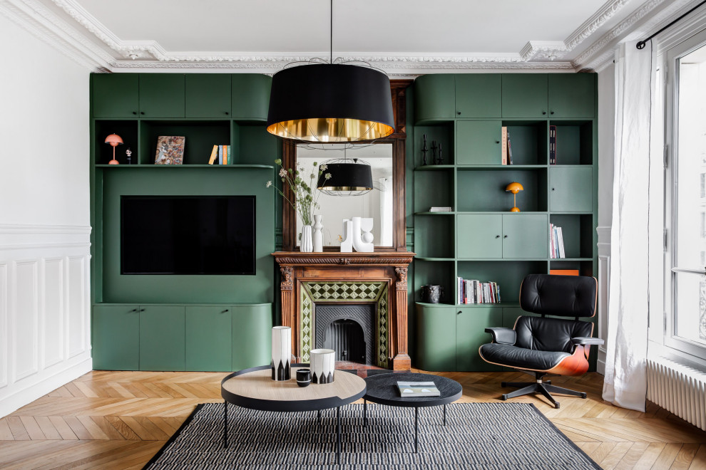 Inspiration for a large contemporary open concept living room in Paris with a library, green walls, light hardwood floors, a standard fireplace, a wood fireplace surround, a built-in media wall and decorative wall panelling.