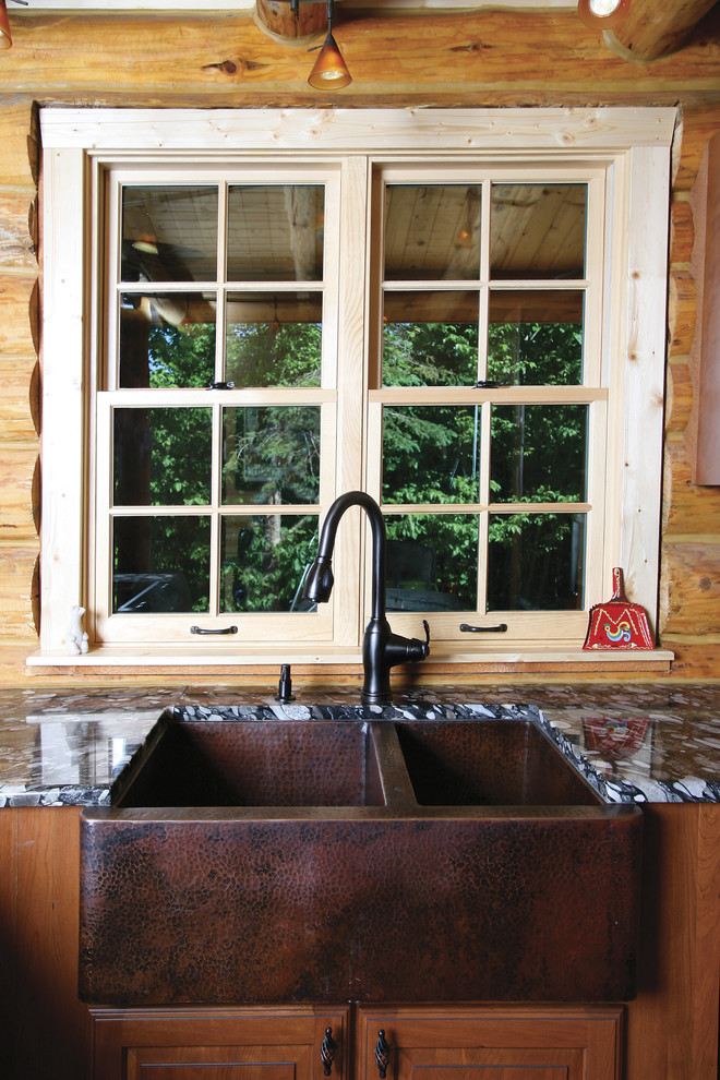 Example of a small mountain style u-shaped kitchen design with a farmhouse sink, raised-panel cabinets, medium tone wood cabinets, granite countertops, brown backsplash, wood backsplash, black appliances and a peninsula