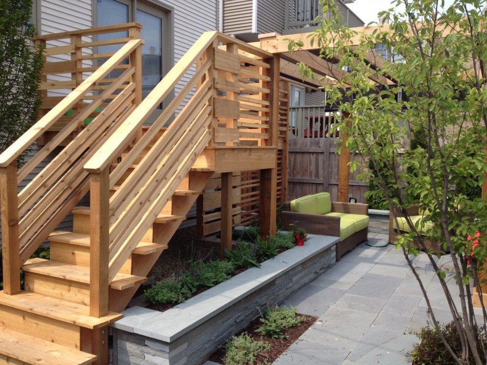 This is an example of a mid-sized modern backyard deck in Chicago with a pergola.