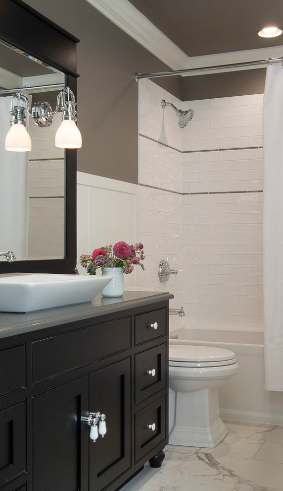 Design ideas for a small transitional 3/4 bathroom in St Louis with recessed-panel cabinets, dark wood cabinets, an alcove tub, an alcove shower, a two-piece toilet, white tile, subway tile, grey walls, marble floors, a vessel sink and engineered quartz benchtops.