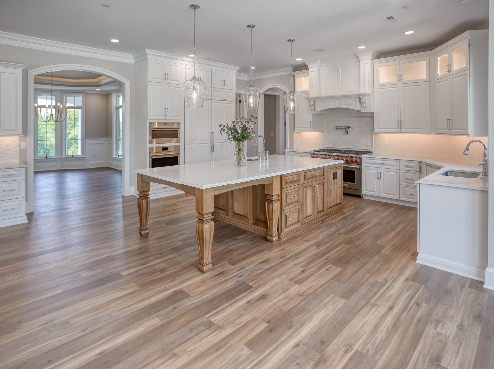 Transitional Kitchen with Two Toned Gathering Island & Archways
